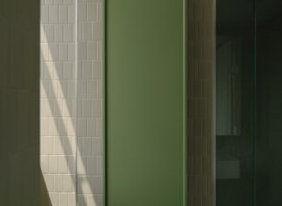 A shaft of light hits the bathroom tiles and cupboard by DesignOffice in Bedford by Milieu residential development